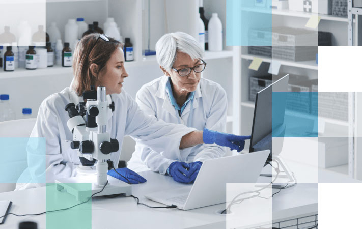 Two female eye care professionals completing eye care research on a computer.